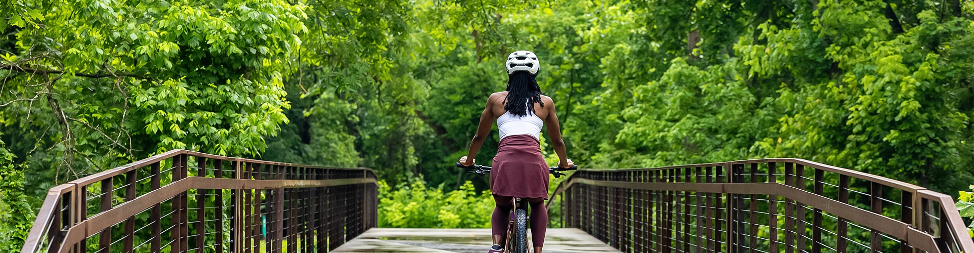 a woman riding a bicycle on a bridge