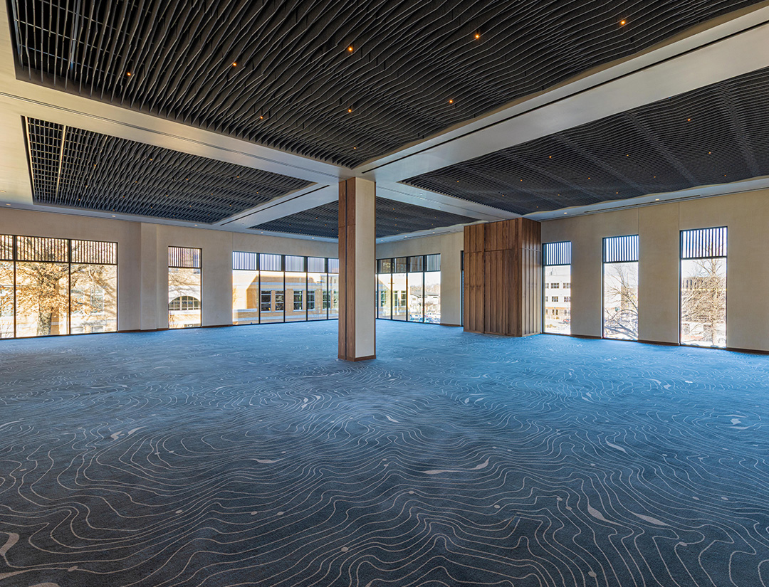 a large room with a large column and a carpeted floor