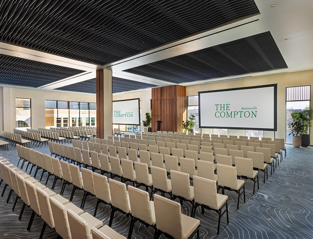a room with rows of chairs and a projector screen