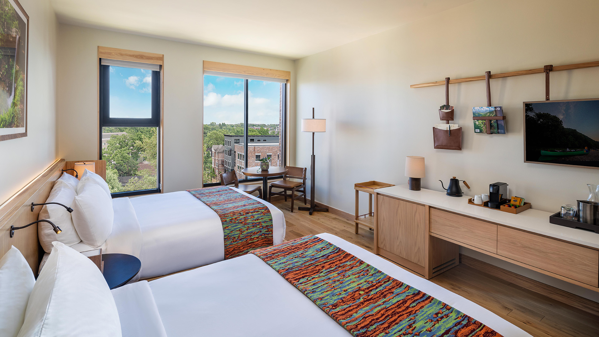 a room with two beds and a table and chairs