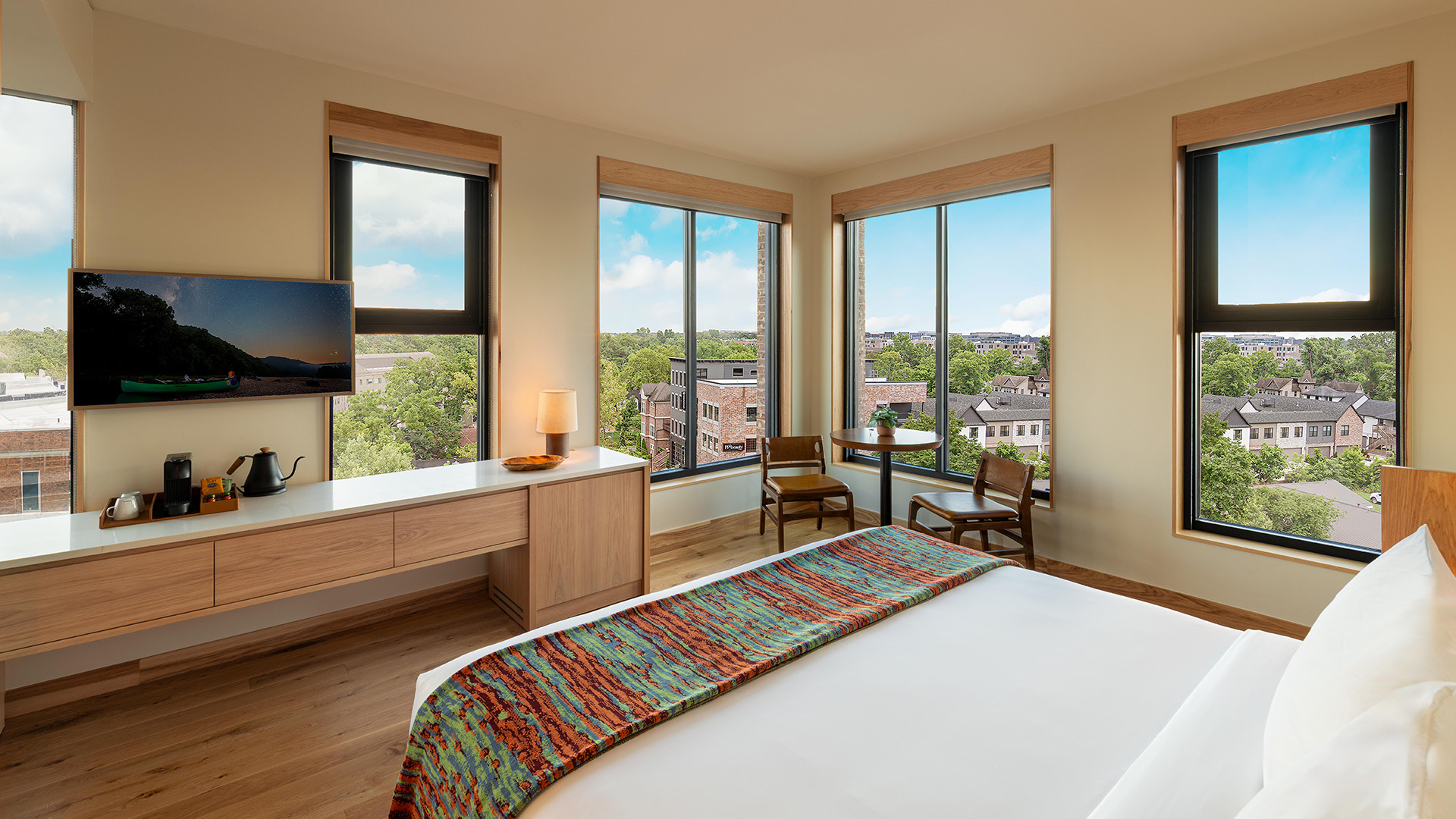 a bedroom with a bed and a desk and chairs