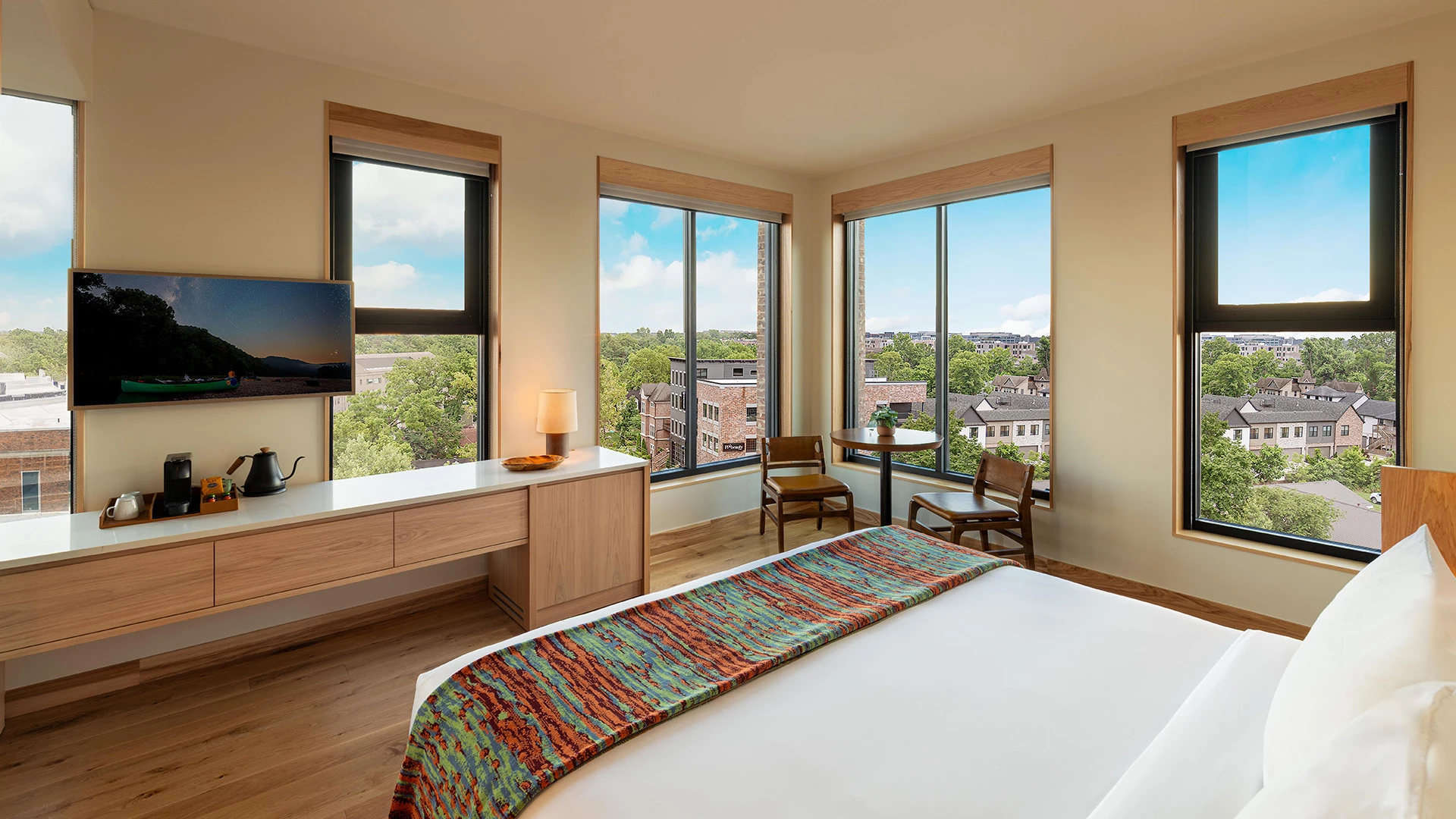 a bedroom with a bed and a desk and chairs
