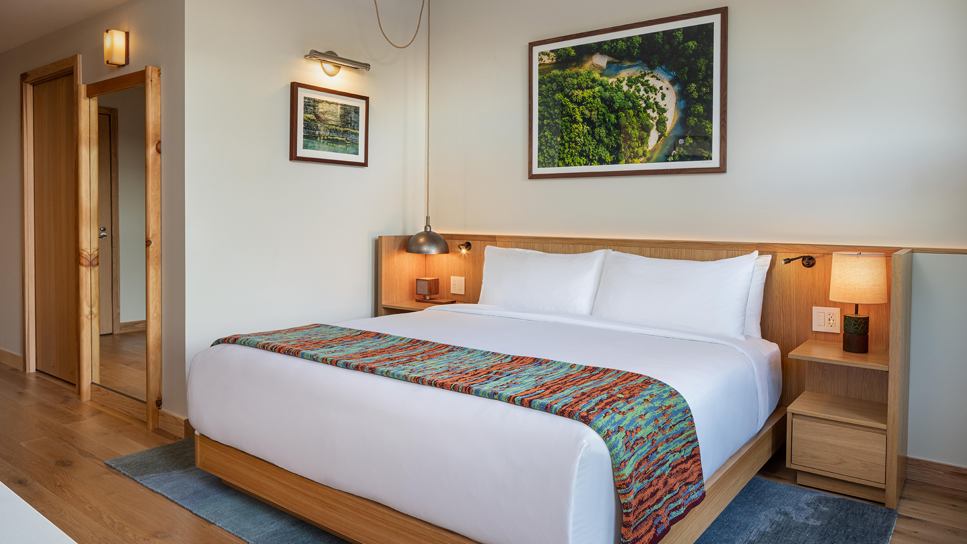 a bed with a lamp and a picture on the wall