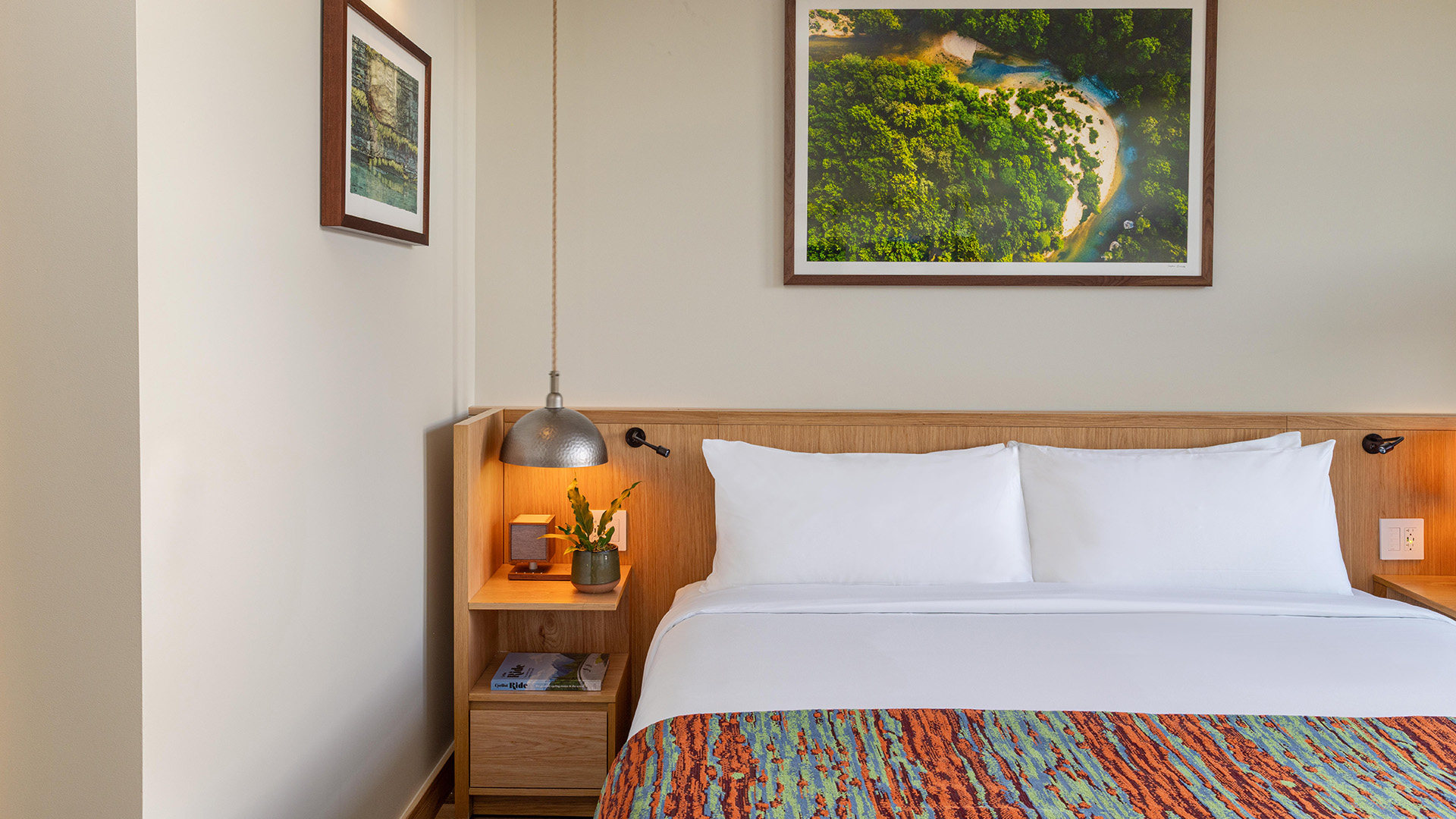 a bed with a lamp and a picture on the wall