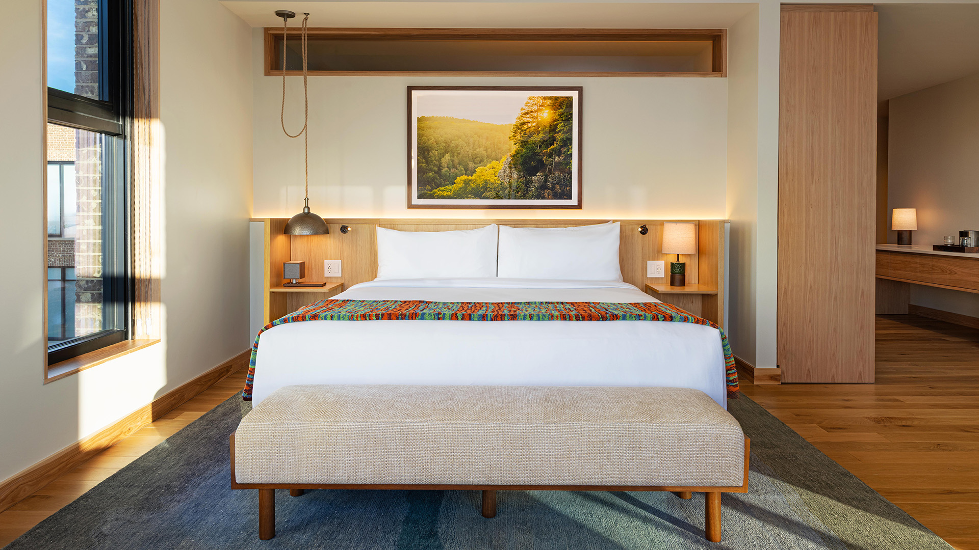 a bed with a bench and a picture above it