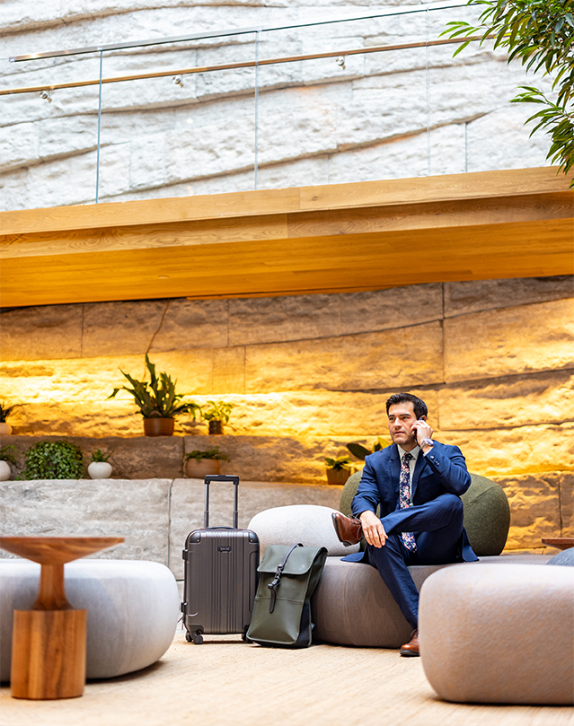 a man in a suit sitting on a couch with luggage