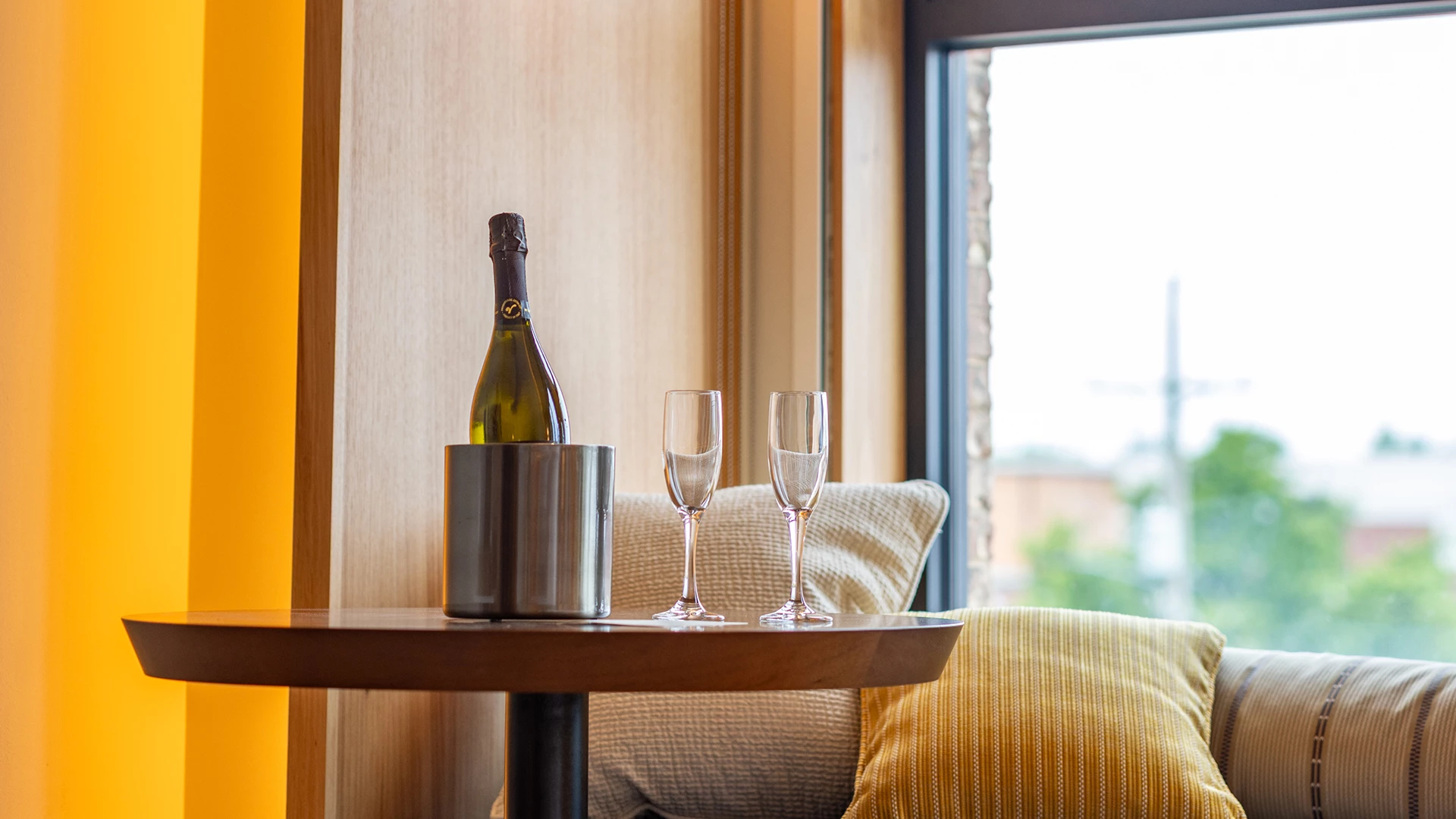 a bottle of champagne in a bucket and two wine glasses on a table
