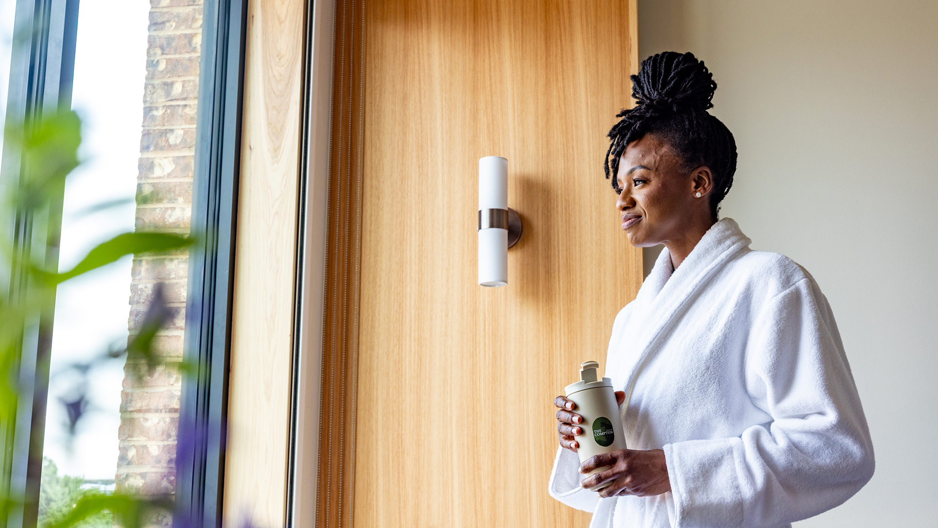 a woman in a white robe holding a coffee cup