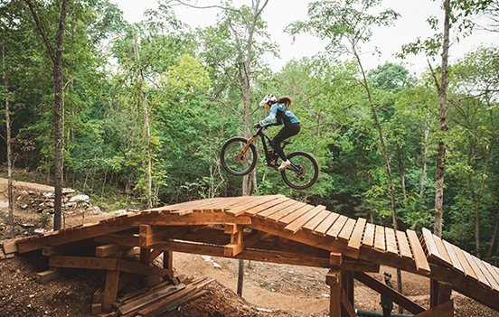 a person riding a bike over a bridge