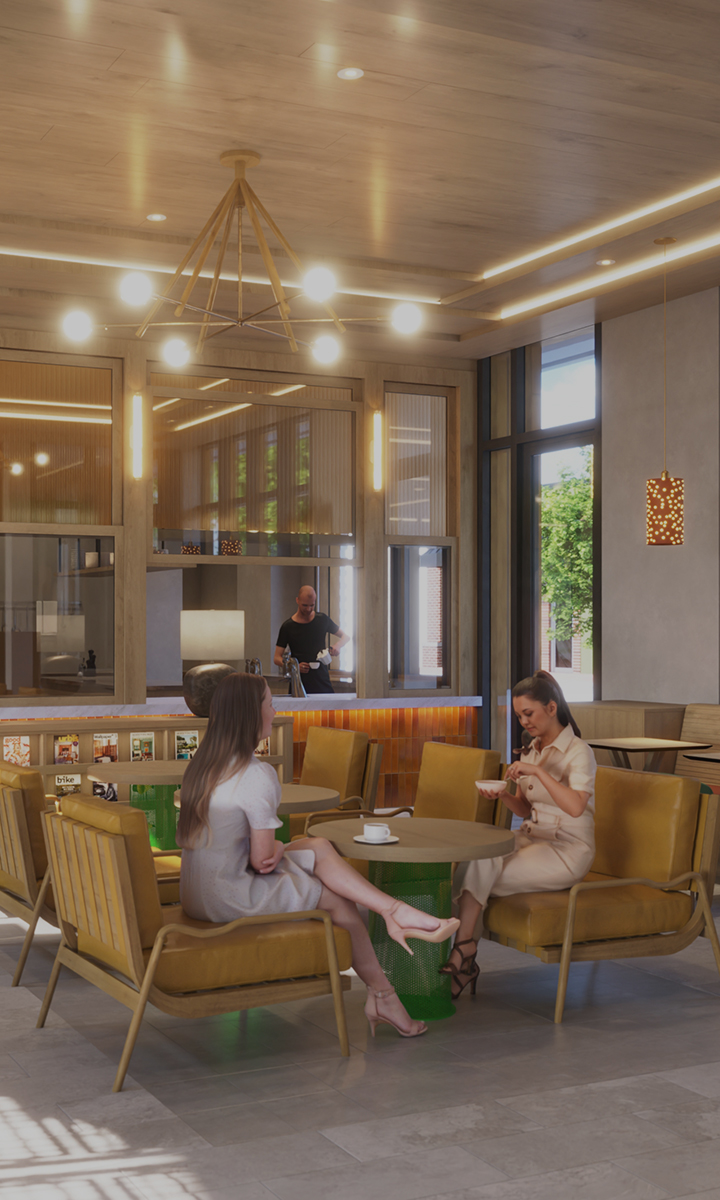 a couple of women sitting at a table in a room with a man in the background