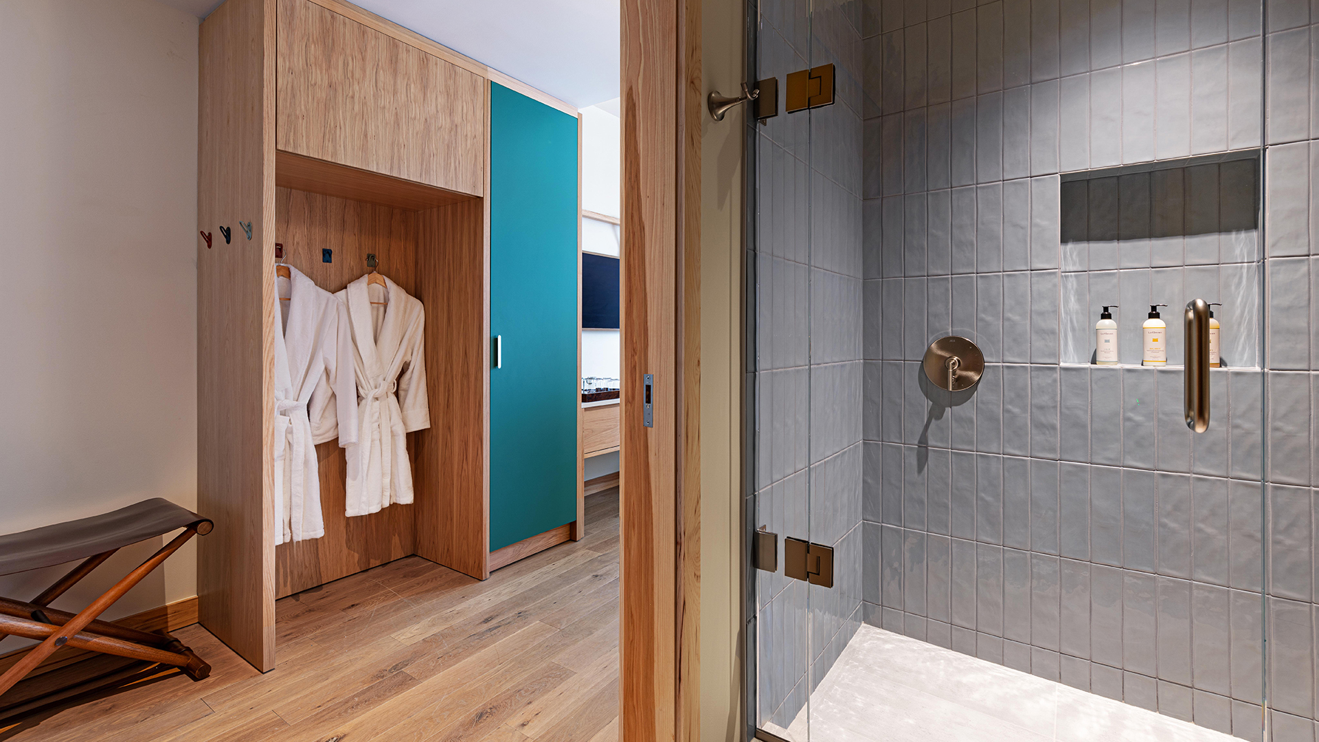 a bathroom with white bathrobes and a glass shower