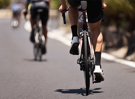 a pair of cyclists riding on a road