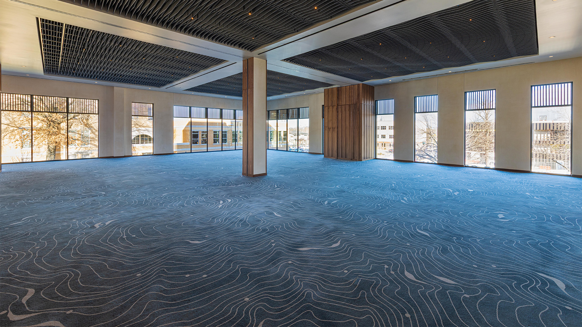 a large room with blue carpet and windows