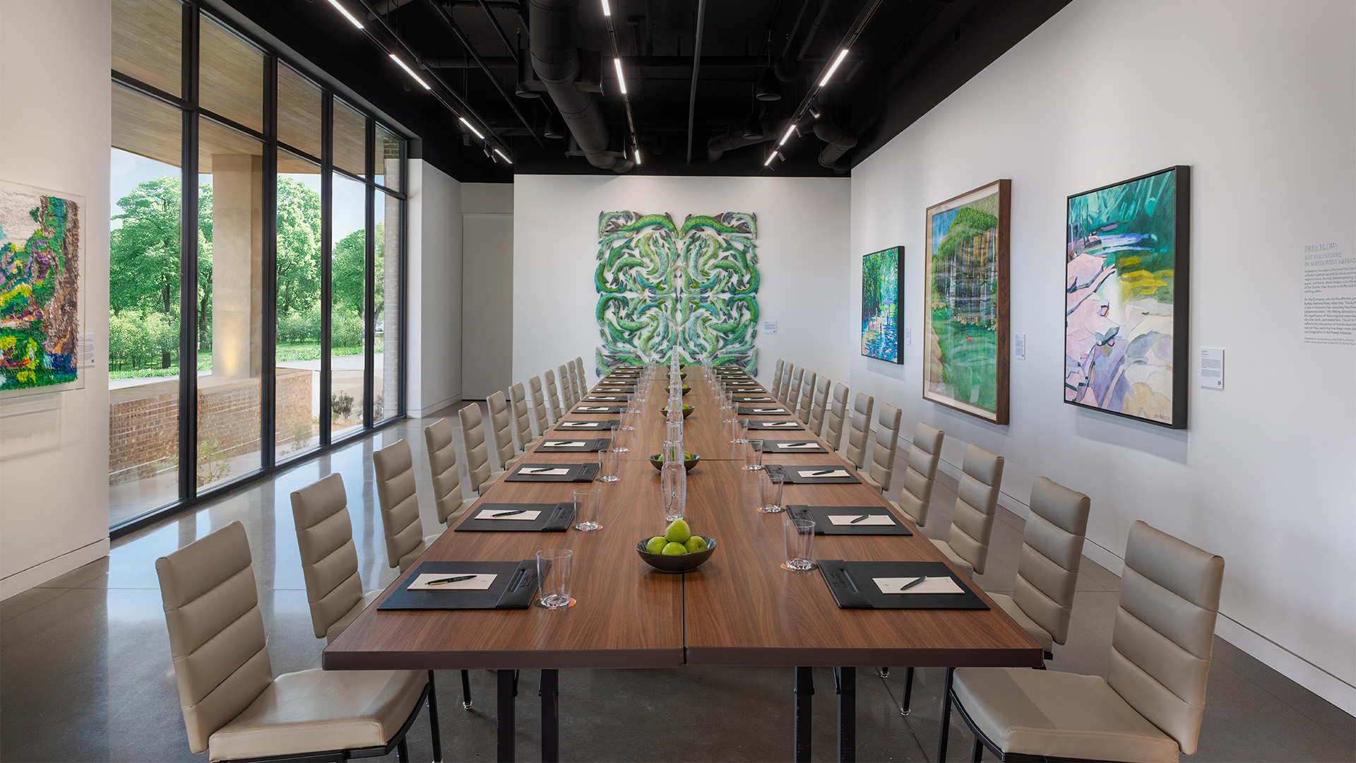 a long table with glasses and a bowl of fruit on it