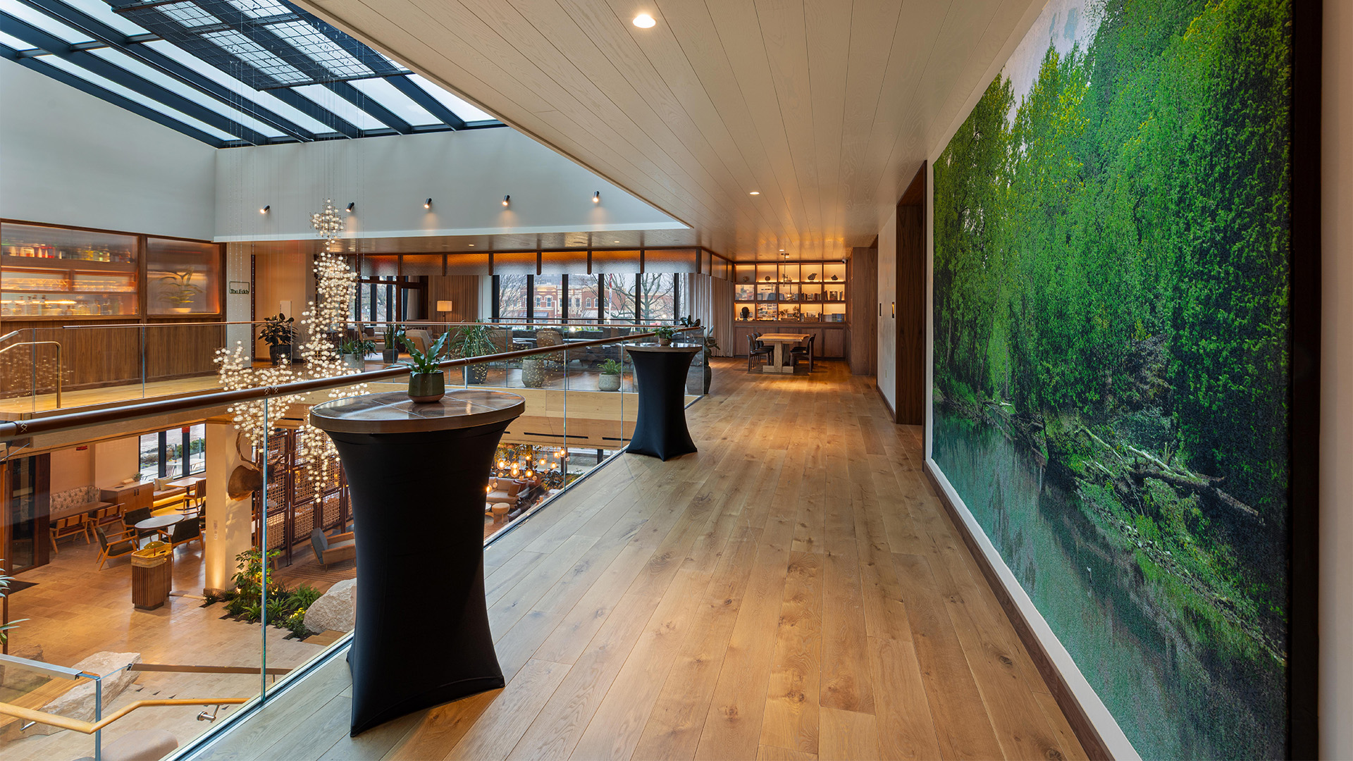 a room with a large window and a large wall with a picture of a tree