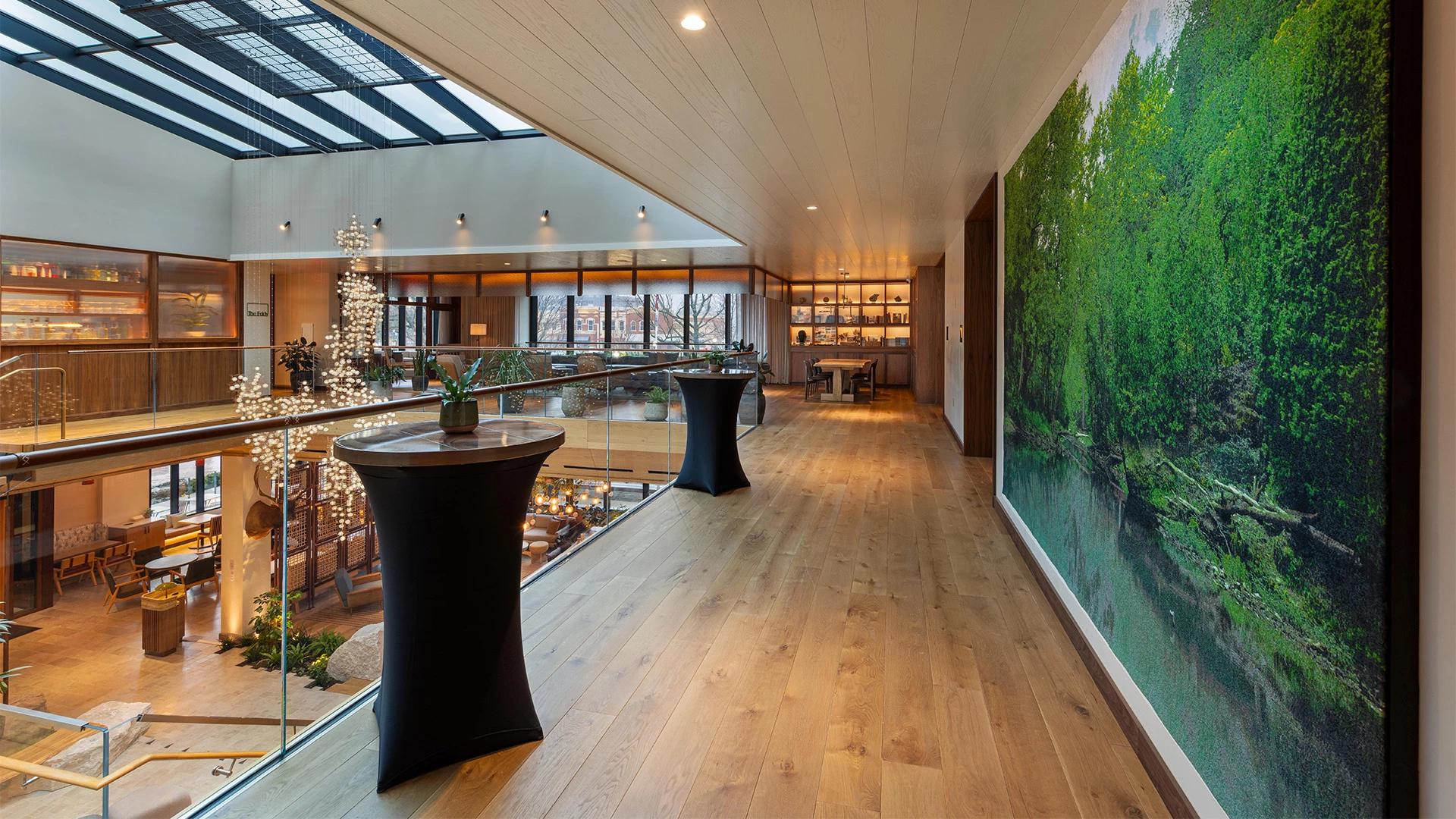 a room with a large window and a large wall with a picture of a tree