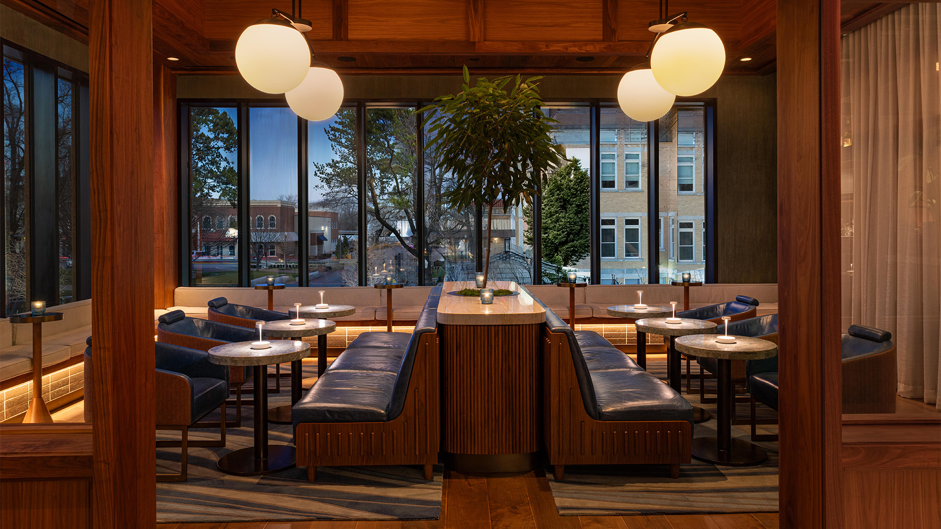 a room with tables and chairs and a tree