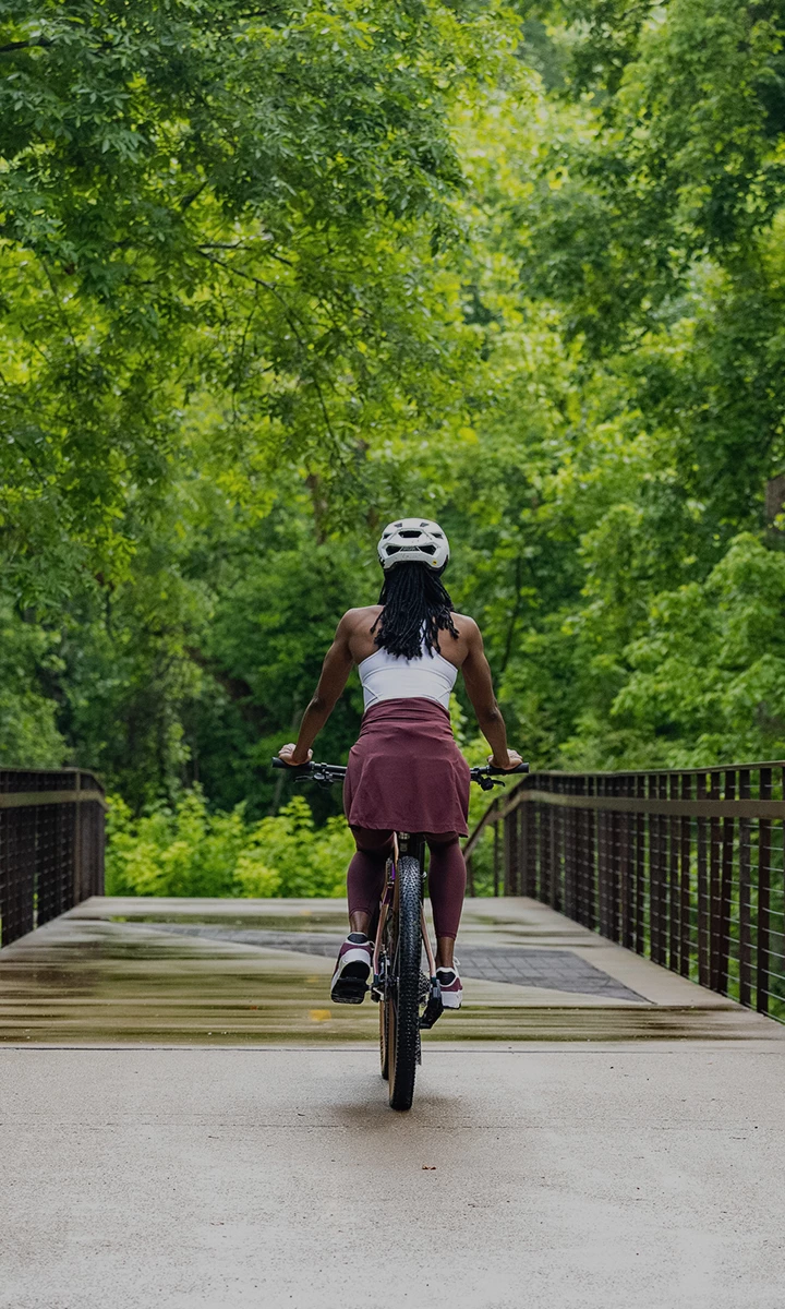 a woman riding a bicycle on a bridge