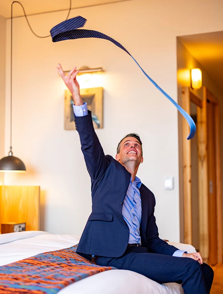 a man in a suit throwing a blue tie