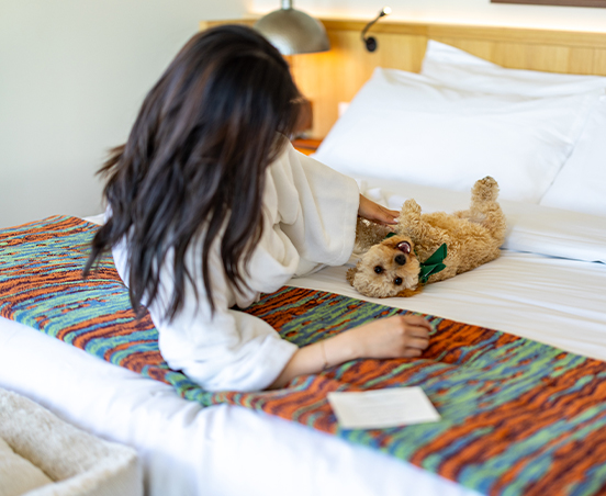 a woman petting a dog on a bed