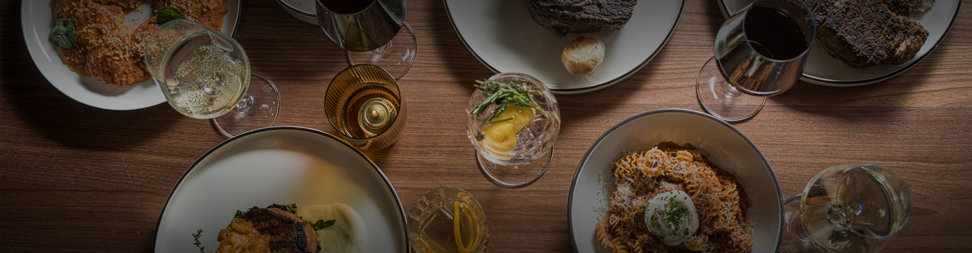 a table with plates of food and glasses of wine