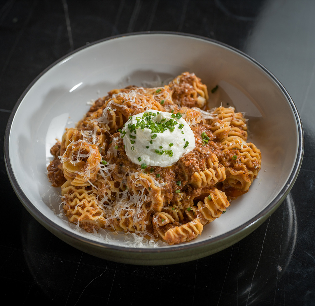 a bowl of pasta with sauce and cheese