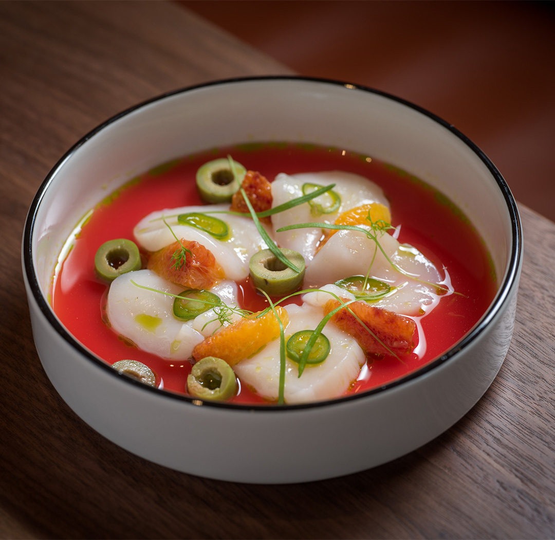a bowl of soup with scallops and green onions