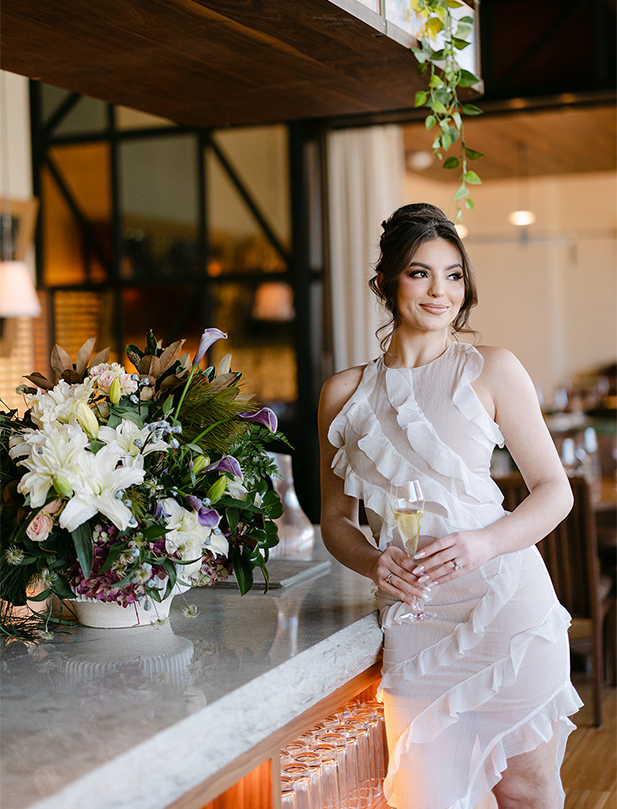 a woman in a white dress holding a glass of champagne