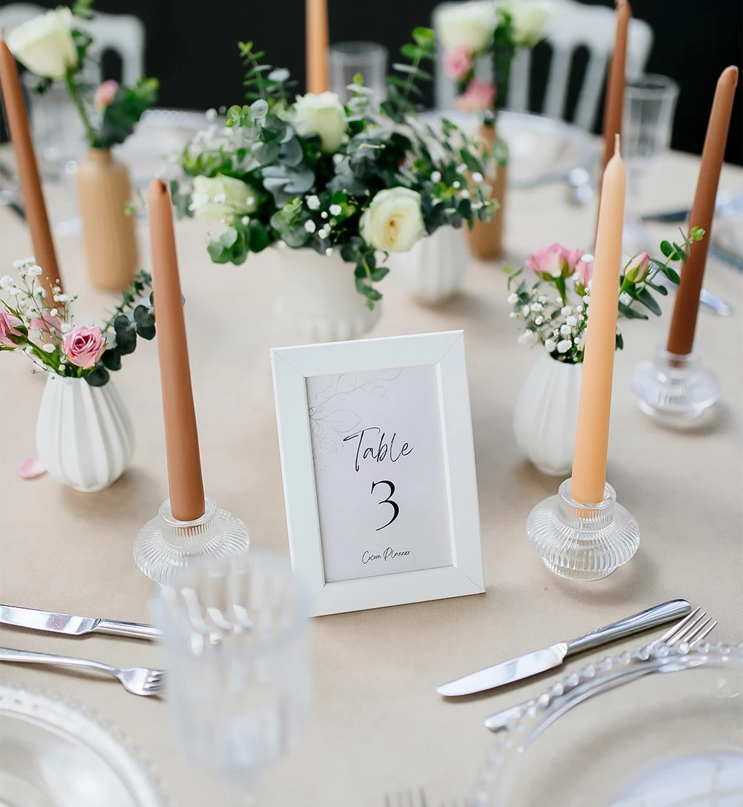 a table with a picture frame and candles