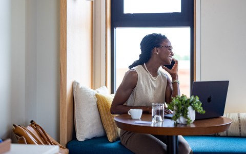 a woman sitting at a table talking on a cell phone
