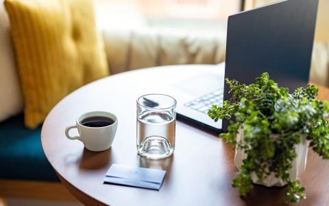 a cup of coffee and a laptop on a table