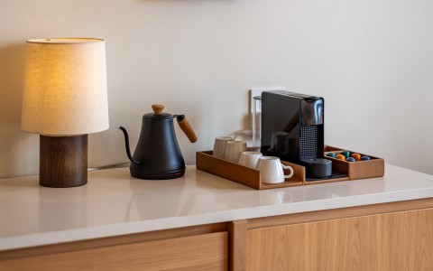 a coffee maker and mugs on a counter