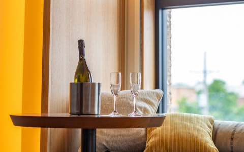 a bottle of champagne in a bucket and two wine glasses on a table