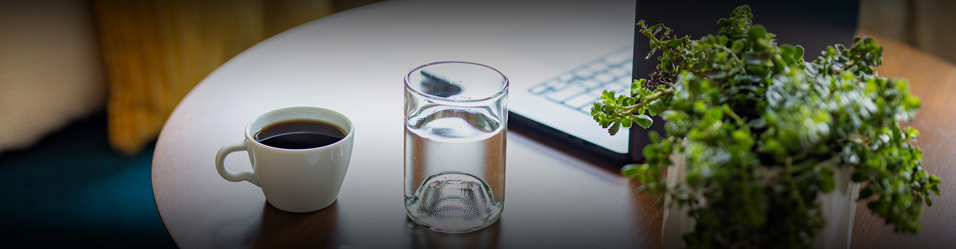 a glass of water next to a laptop