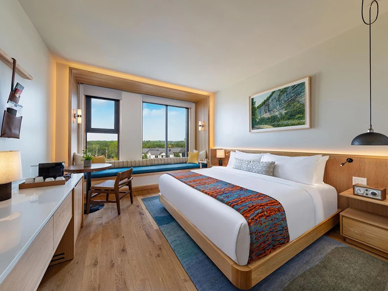 a room with a bed and a desk and a window