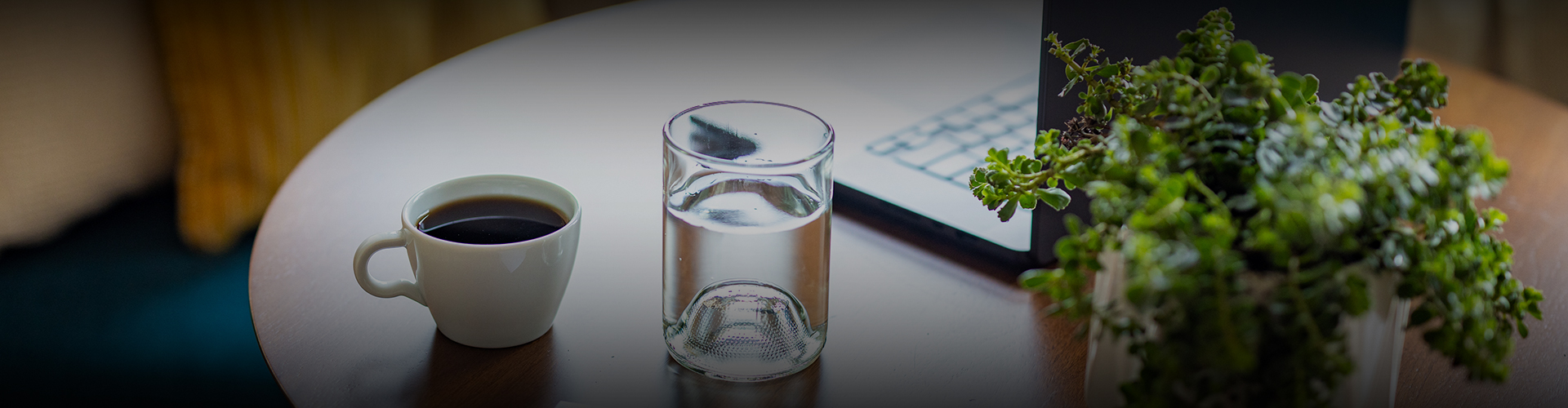 a glass of water next to a laptop