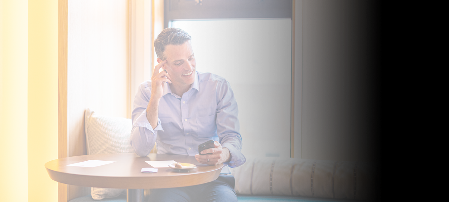 a man sitting at a table looking at his phone