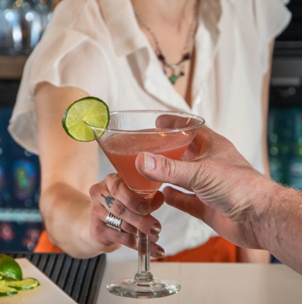 bartender passing martini over the bar
