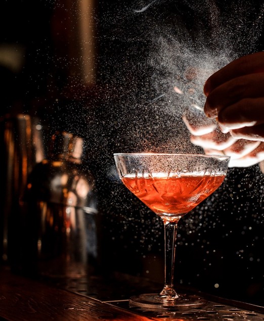 View of a barman preparing a red cocktail 