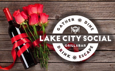 a bottle of wine and roses on a wood surface