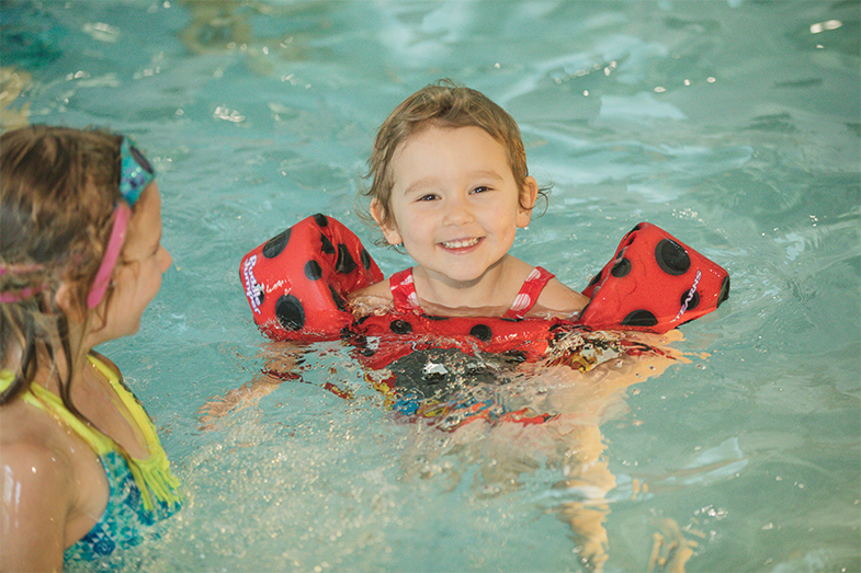 a child in a pool with a toy brush