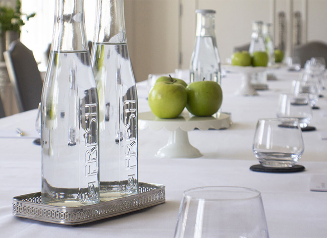 a table with a group of glasses and bottles of water