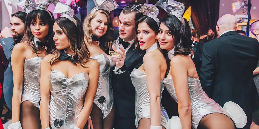 playboy bunnies posing with man
