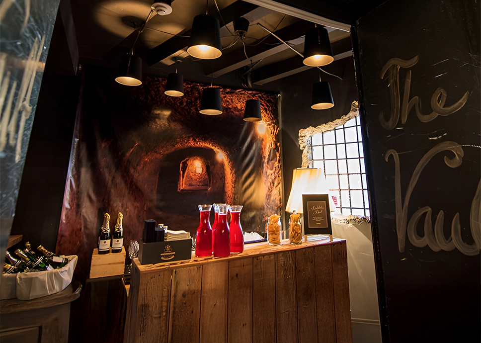 a table with red bottles and a poster on the wall