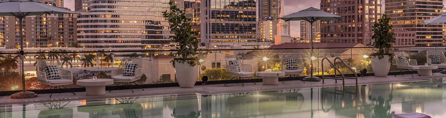 pool with pink city buildings in the background