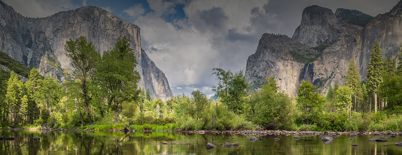 a river with trees and mountains in the background