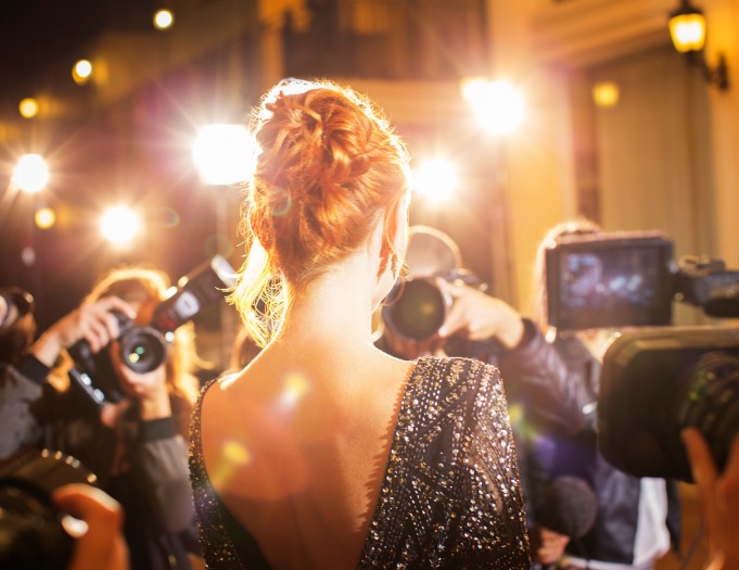 a woman in a dress with a group of photographers