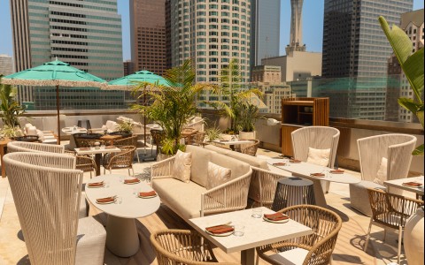 a rooftop restaurant with a city skyline in the background