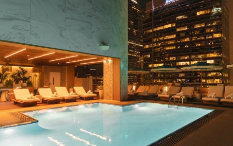 a pool with lounge chairs and a building in the background