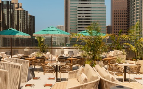 a rooftop restaurant with tables and umbrellas